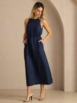 [Dark Blue] navy blue sleeveless scoop-neck midi dress, gathered waist and side pockets, full front view, body angled to one side. 003