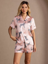 [Pink Zebra] pale pink animal-print short pajama set with contrast piping, full front view, model with both hands in the pockets. 001