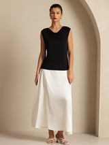 [Black] Front view from head to toe: black sleeveless cowl-neck top with a white maxi skirt, with the hem in frame. 005