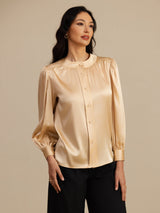 [Champagne] Champagne round-neck lantern-sleeve blouse in a front mid-length view with one hand at her hip. 003