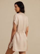[Tan] Waist-up back view of a mulberry silk cap-sleeve short dress with a drawstring waist and side pockets in light tan 002
