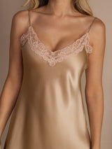 [Champagne] Close studio view of a model wearing a champagne spaghetti-strap mini slip nightdress with lace trim. 008