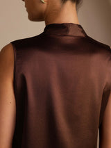 [Bitter Chocolate] Dark brown sleeveless tie-neck top on a model in a rear close crop showing the plain back neckline and shoulder seams. 005