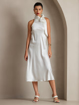 [White] Full front view of a white scarf-neck midi dress, arms lowered and feet set apart to show the flared hem. 008