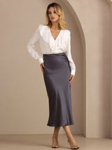 [Dark Gray] Charcoal gray glossy maxi skirt on a model in a full-body front view with one hand at her hip and weight shifted. 001