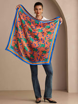 [Clay Elephant] Held-open view of a 90 cm silk scarf in coral pink with blue, green, and brown animal silhouettes and a blue border 005