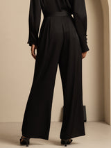 [Black] Angled view: black high-rise wide-leg trousers with a black blouse, with the model turned sideways. 002