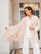 [Beige] very pale pink rectangular shawl with fringed edges, styled front view, one side extended outward to show the width. 001