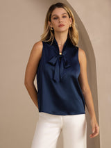 [Dark Blue] Navy blue sleeveless tie-neck top on a model in a mid-length front view with both arms held behind her back. 001