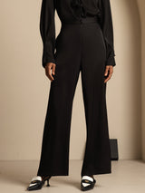 [Black] Black wide-leg trousers with a black blouse in a front chest-to-shoes view, the wide trouser legs and shoes visible. 003