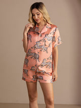 [Pink Cat] Peach pink cat-print short pajama set with contrast piping, three-quarter front view, one hand raised near the face. 005