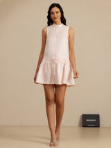 [Pink] Blush-pink sleeveless drop-waist mini dress with gathered ruffle hem in a full front view, with the lower hem visible. 007