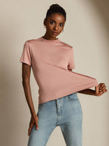 [Pink] Frontal mid-length frame: blush-pink short-sleeve crew-neck top with light blue jeans, with one arm bent. 001