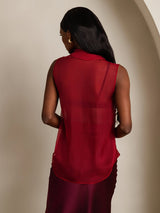 [Wine] Rear studio view of a model wearing a sheer burgundy sleeveless bow-neck blouse with a matching skirt. 002