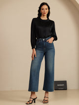 [Black] Black round-neck lantern-sleeve blouse on a model in a full-body front view with one hand tucked into a side pocket. 007