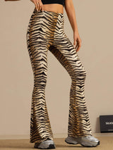 [Tiger] Mid-length front crop: high-rise flared trousers with a brown-and-black tiger stripe print, with one arm lifted. 001