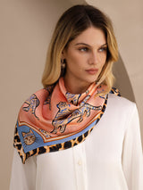 [Pink Cat] Coral pink animal-print square scarf with blue-and-black patterned border, styled front, diagonal shoulder drape. 002
