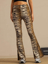 [Tiger] Three-quarter view: high-rise flared trousers with a brown-and-black tiger stripe print, with the body turned. 003
