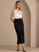 [Black] Black glossy maxi skirt on a model in a full-body front view with one hand at her hip and weight shifted. 005