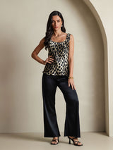 Leopard print silk sleeveless U-neck tank top styled with black wide-leg pants