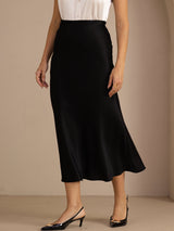 [Black] Black glossy maxi skirt on a model in a waist-to-ankle front crop with one leg stepping forward. 004