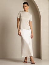 [Gray] Full front view of a light gray short-sleeve crew-neck top with a white maxi skirt, arms lowered. 009