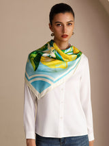 [Blue Lemon] Aqua-and-white square lemon scarf with green leaves and pale border, styled close-up, wrapped at neck, hand near chin. 003