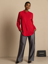 [Wine] Full-length view: red long-sleeve collared blouse with gray wide-leg trousers, with weight shifted to one leg. 007