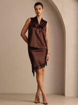 [Bitter Chocolate] Dark brown sleeveless tie-neck top on a model in a full-body front view with one hand at her hip and weight shifted. 006