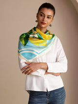 [Blue Lemon] Aqua-and-white square lemon scarf with green leaves and pale border, styled front view, over shoulders, arms crossed. 005