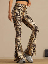 [Tiger] High-rise flared trousers with a brown-and-black tiger stripe print in a waist-up front view, with both arms down. 004