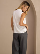 [White] Mid-length back studio view of a model wearing white sleeveless tie-neck blouse. 002