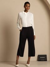 [White] Complete body view: white long-sleeve collared blouse with black wide-leg trousers, with weight shifted sideways. 007