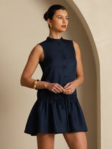 [Dark Blue] Mid-length front crop: navy sleeveless drop-waist mini dress with gathered ruffle hem, with one arm lifted. 001
