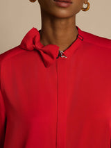 [Wine] Close studio view of a model wearing a red long-sleeve collared blouse with gray wide-leg trousers. 004