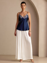 [Dark Blue] Navy blue camisole with slim straps and pale floral-lace V-neck, full front view, model standing with both arms relaxed. 006