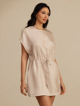 [Tan] light tan cap-sleeve short dress with drawstring waist and pockets, waist-up view, body angled, gaze aside. 003